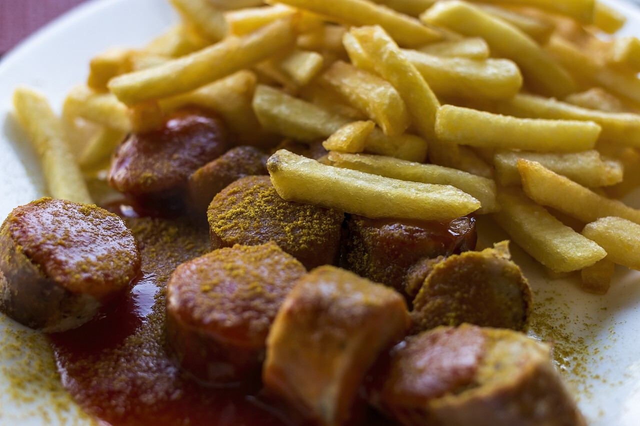 Traditional German currywurst - pieces of sausage with curry sauce ...