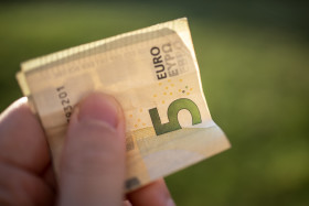 Stock Image: 5 euro banknotes in hand - pay with five euro