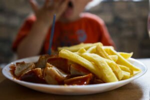 child eats currywurst with chips 02