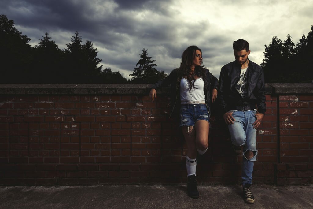 couple is leaning against a wall