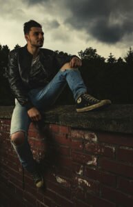 sitting man on brickwall